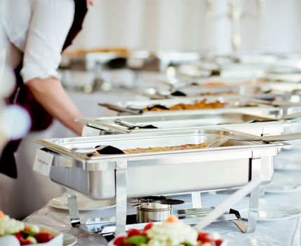 Profissional organiza serviço de catering para evento no almoço corporativo